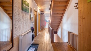Ein Innenraum mit Holzboden, einer Treppe, einem Heizkörper und einer Tür.