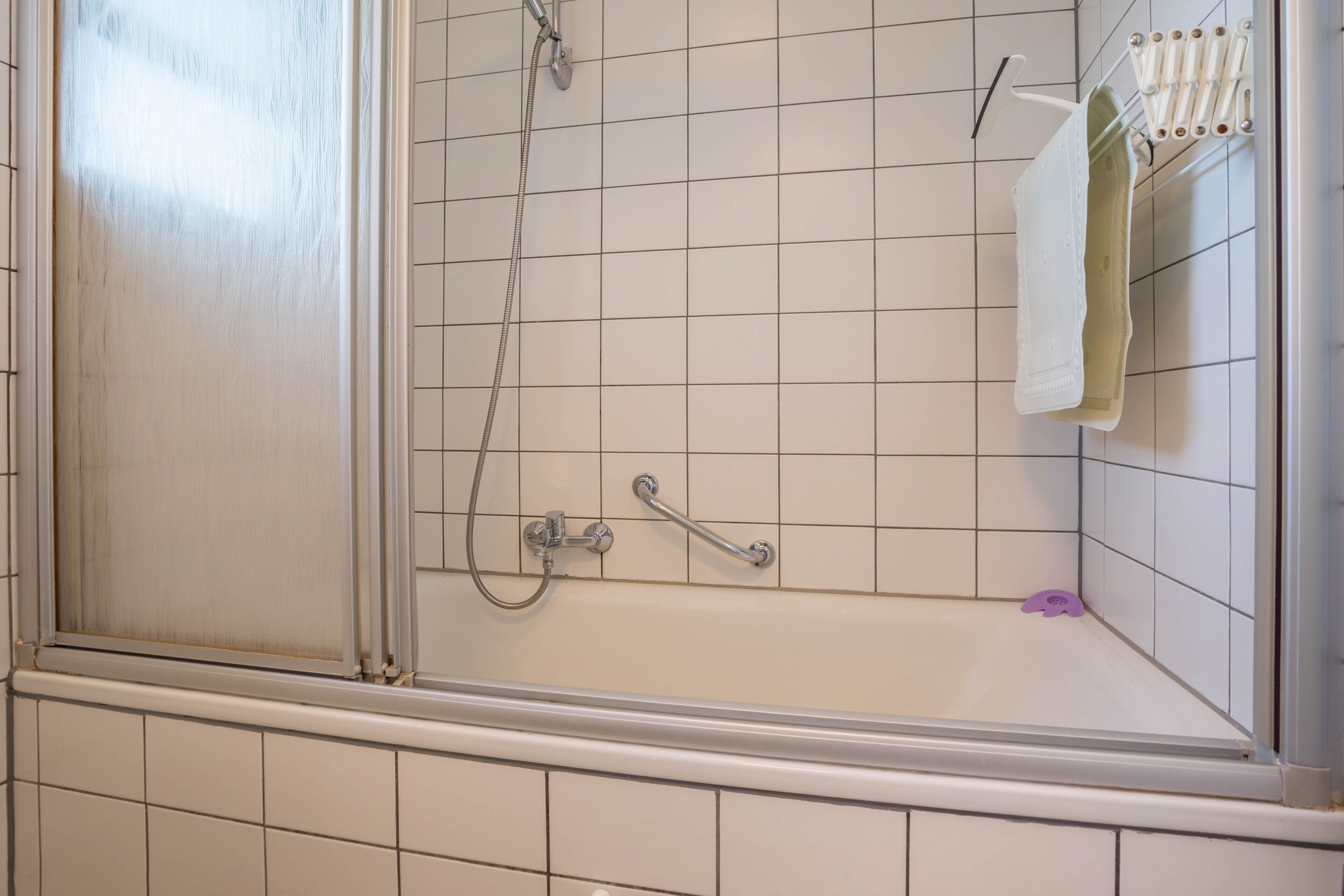 A bathroom with a shower, a toilet, and a sink.