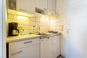 A kitchen with a coffee maker, sink, and dishwasher. - Apartment 'Nordhaus 1' close to the Beach with Shared Garden & Wi-Fi (Cuxhaven)