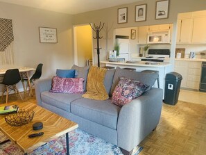 Relax in this stylish living room with a sofa, coffee table, and dining area.