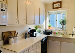 Enjoy cooking in this well-equipped kitchen with a coffee maker, kettle, and dish rack.