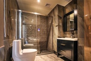 A modern bathroom with a glass-enclosed shower, a white toilet, and a black vanity with a mirror. - Park Lane Hotel (Jiangmen Shuinan) (Jiangmen)