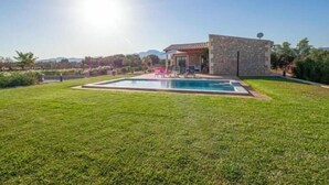 A modern house with a swimming pool, stone exterior, and a view of the mountains. - El Rafal de Son Alberti Petitona (Buger)