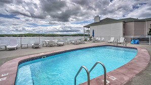 A swimming pool with lounge chairs and a view of the lake. - Water Views + Pool Access: Lake Ozark Escape! (Lake Ozark)