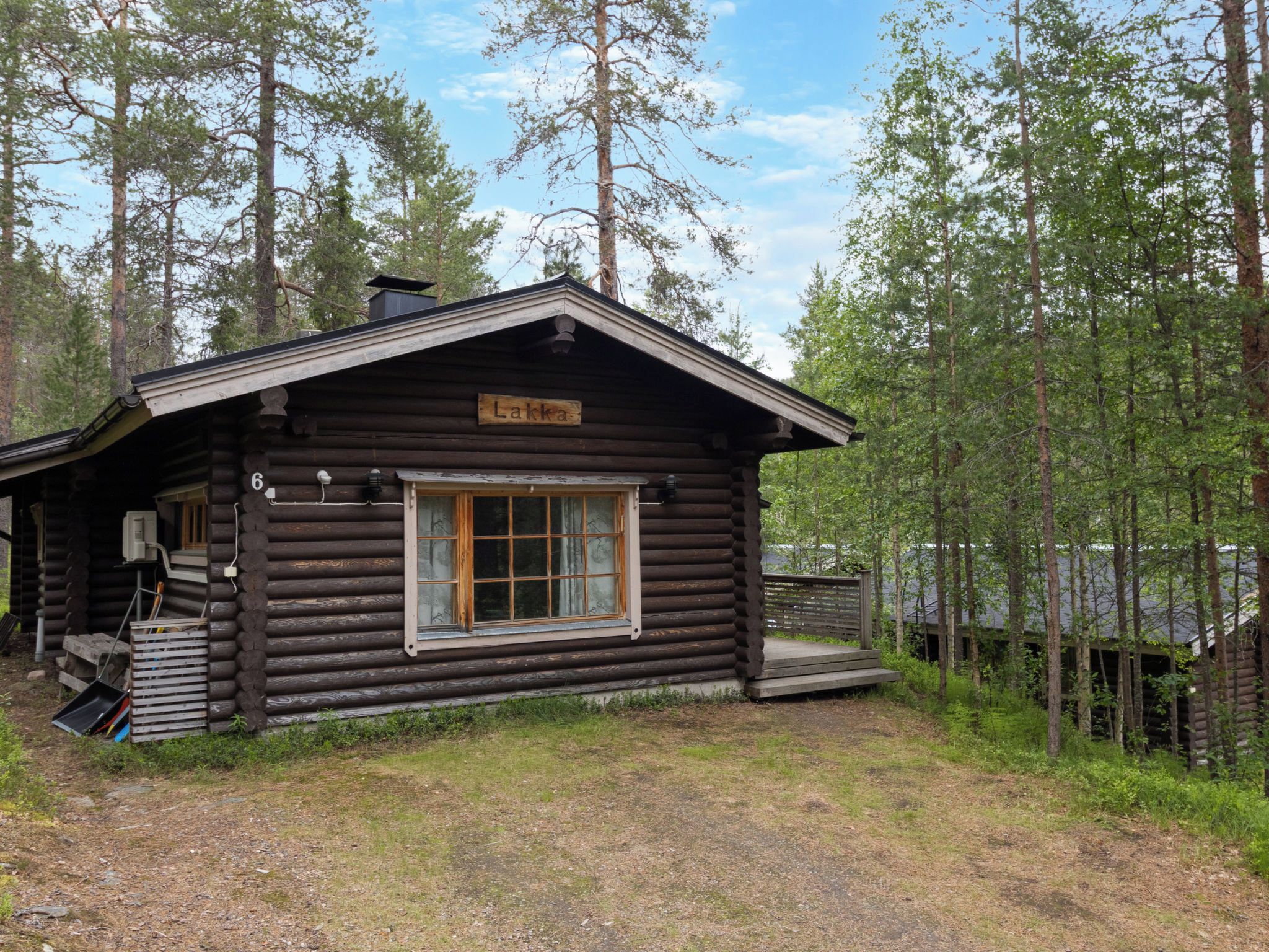 A log cabin with a sign reading 'Lakka,' a window, and a small porch area.