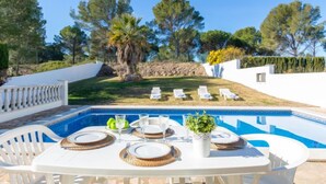 A poolside dining area with a table set for four, surrounded by white chairs. - Villa Marc by Interhome (L'Escala)