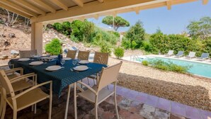 A covered outdoor dining area with a pool and lounge chairs. - Cascabelle by Interhome (Sainte Maxime)