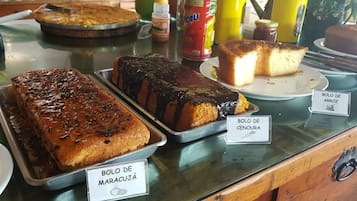 Exposição de diversos produtos de panificação com etiquetas mostrando seus nomes.