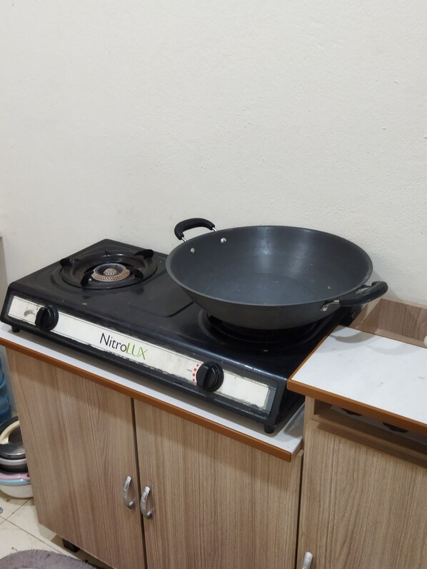 A kitchen with a stove and a frying pan. - Village atmosphere but like on the beach (Bachok)