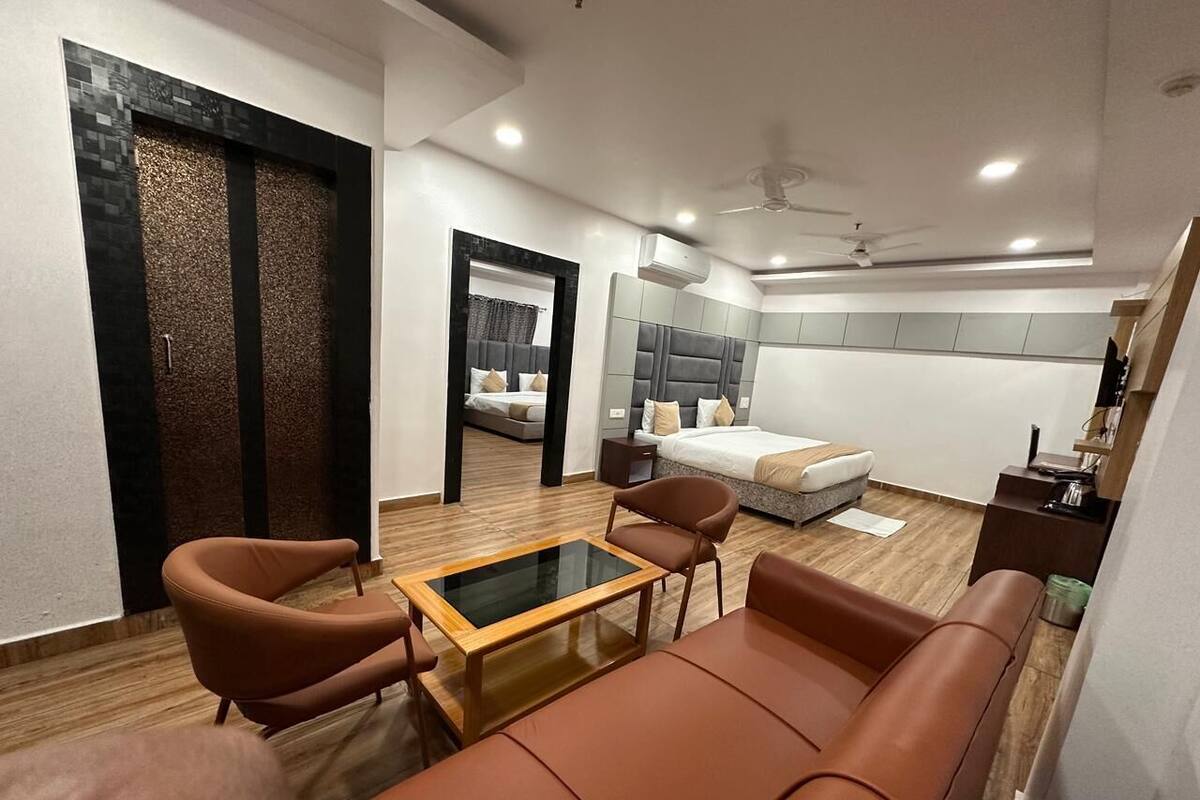 A modern living room with a sofa, armchairs, and a glass-top coffee table.
