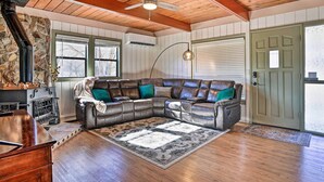 A cozy living room with a sectional sofa, a fireplace, a wooden ceiling, and a stone wall. - Close to Hiking & Dtwn: Mtn-View Prescott Home! (Prescott)