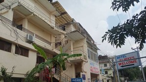A hotel building with multiple balconies, a signboard indicating 'HOTEL ALWAYS WELCOME', and a contact number. - Hotel Always Welcome (Abu Road)