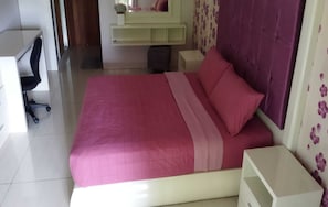 Un dormitorio con una cama grande, un escritorio y una silla.