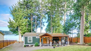 Een chalet met een veranda, een klein terras en uitzicht op een meer.