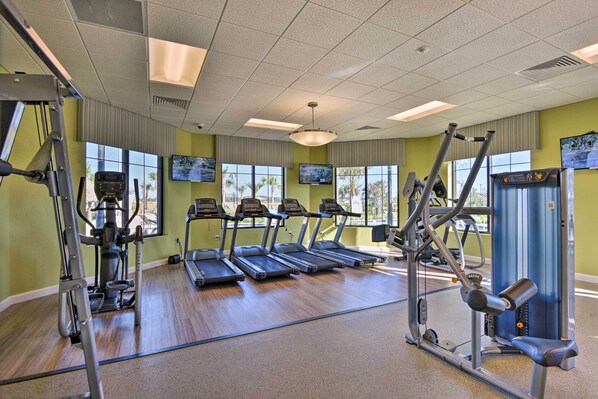 Une salle de sport équipée de tapis de course, d’appareils de musculation et de tapis de sol pour les exercices.