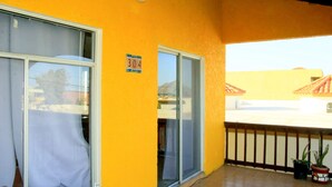 En gul bygning med balkon, skydedør og et skilt med nummer 304.
