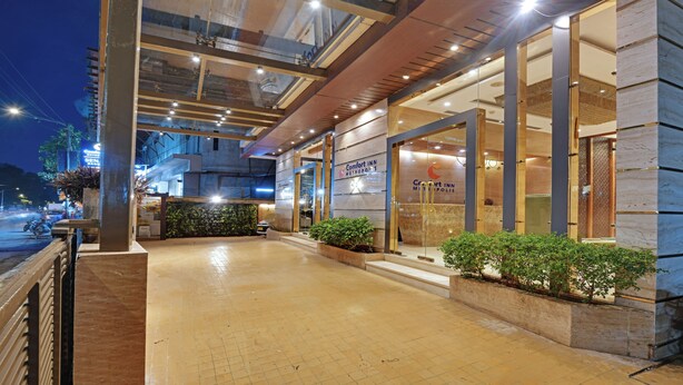 A hotel entrance with a covered walkway, large windows, and a sign for 'Comfort Inn.'
