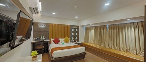 A hotel room with a bed, bedside table, mirror, dresser, and a view of the outside.
