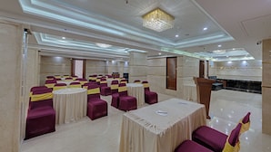 A conference room with round tables, chairs, and a podium.