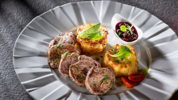 Un piatto di cibo con carne a fette e verdure, guarnito con erbe aromatiche.