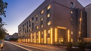 A modern hotel with a brick facade, multiple windows, and illuminated entryways. - Campeador Inn (Cluj-Napoca)