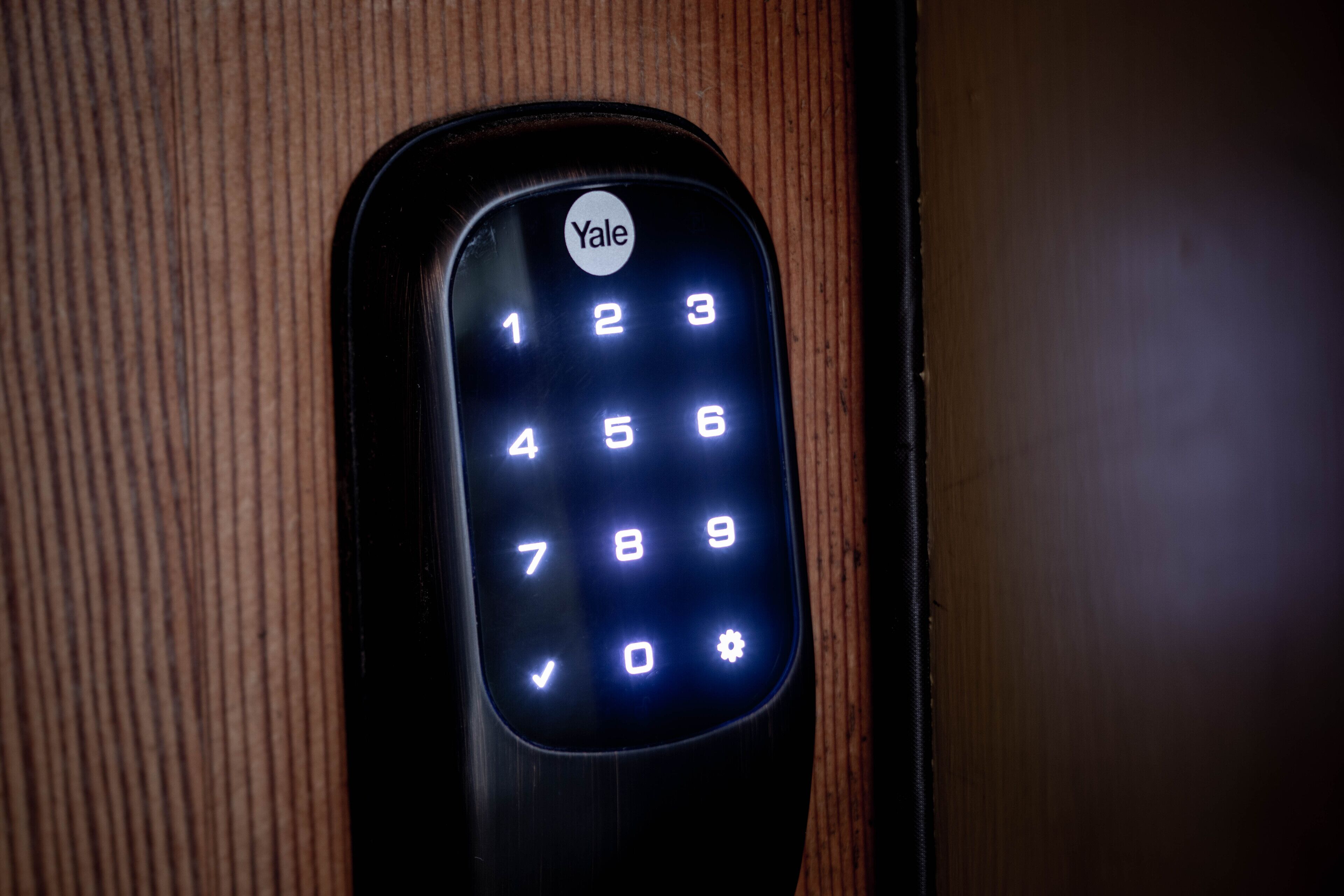 A Yale keypad lock on a wooden door.
