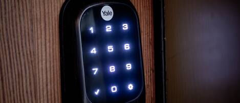 A Yale keypad lock on a wooden door.