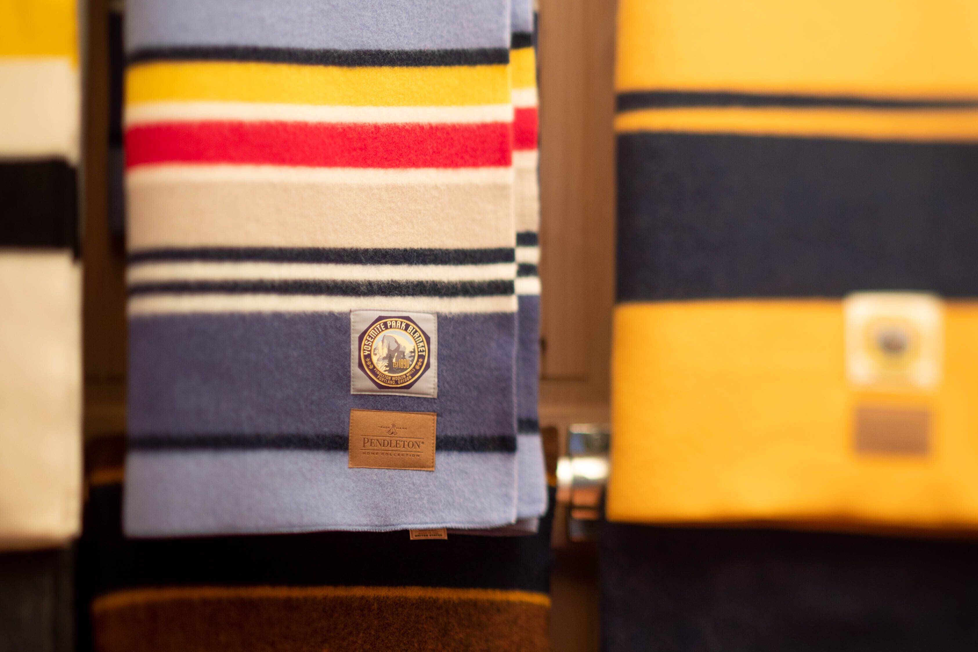 A display of striped blankets with labels.