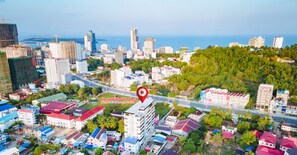 Vista aérea de un paisaje urbano con un hotel destacado señalado con un alfiler rojo.