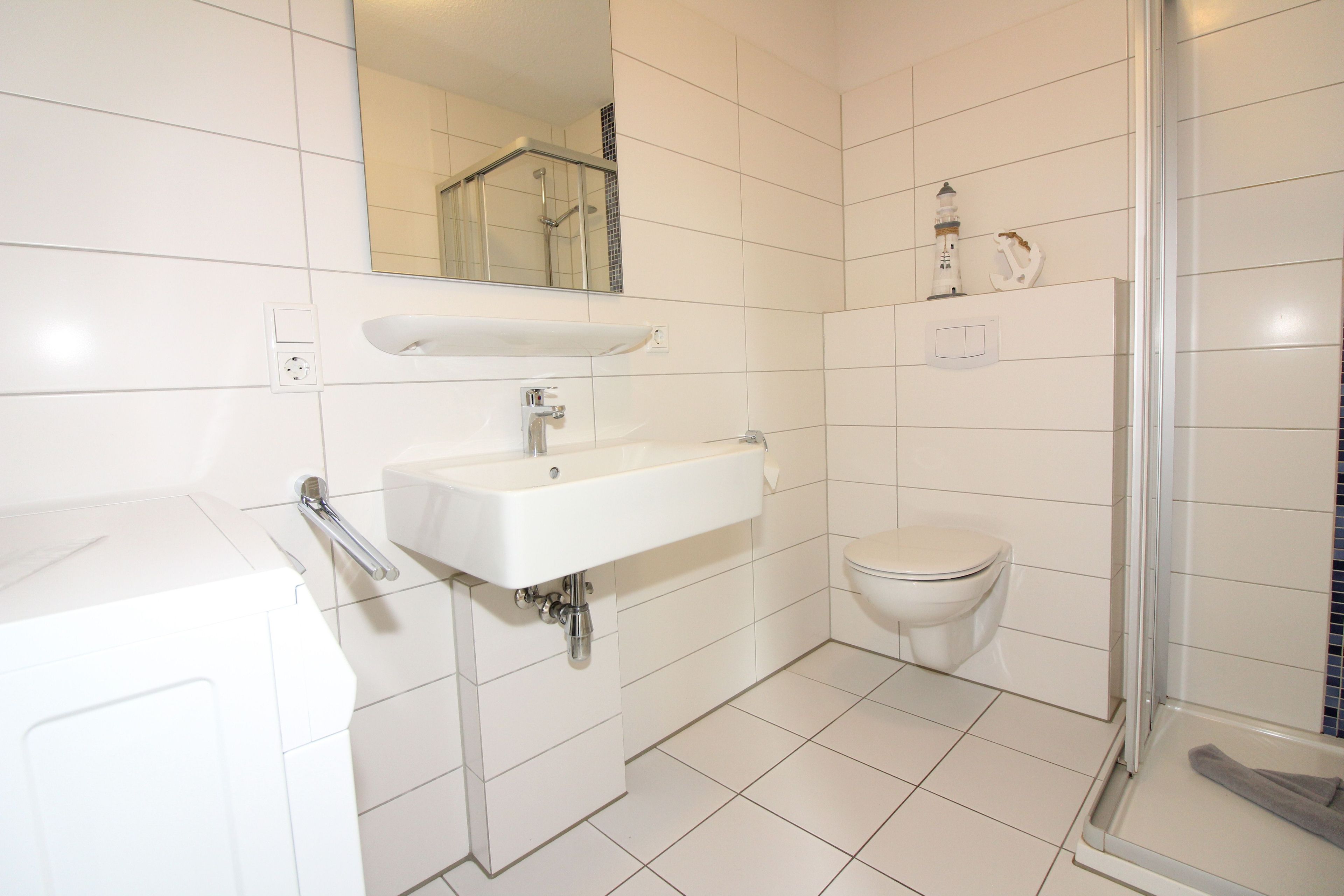 A bathroom with a white sink, a toilet, and a shower area.