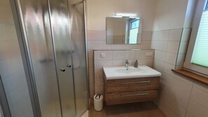 Een douche, een haardroger, zeep, toiletpapier