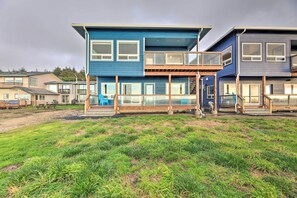 A modern two-story house with large windows and a balcony.