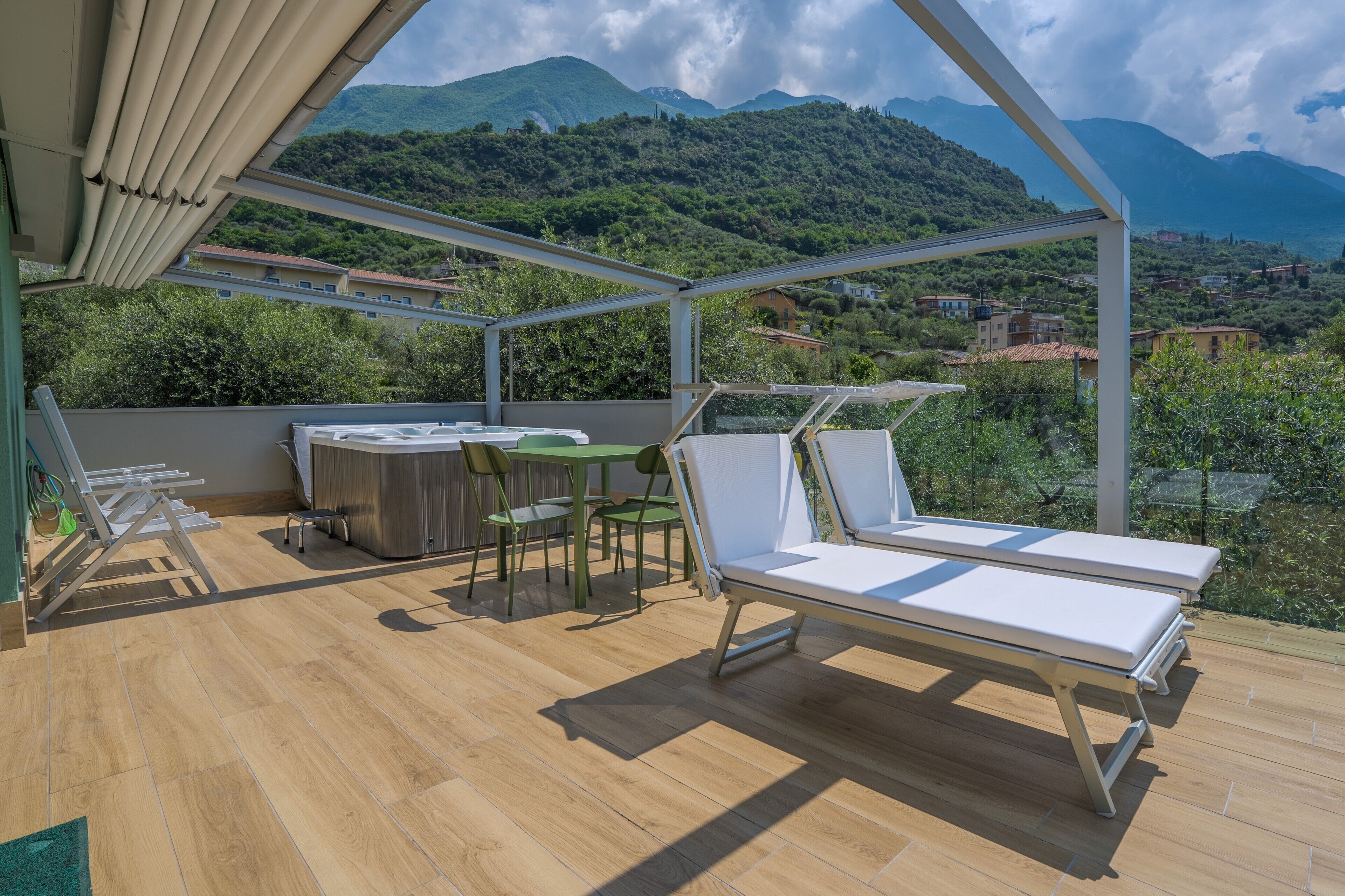 Un espace extérieur abrité, doté d’une terrasse en bois, de chaises longues, d’une table et de chaises.