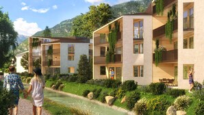 A modern multi-story building with balconies, a garden area with a water feature, and a mountainous backdrop.