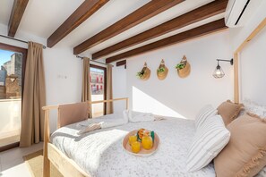 Une chambre avec un lit, un plateau de petit-déjeuner et une vue sur l’extérieur.