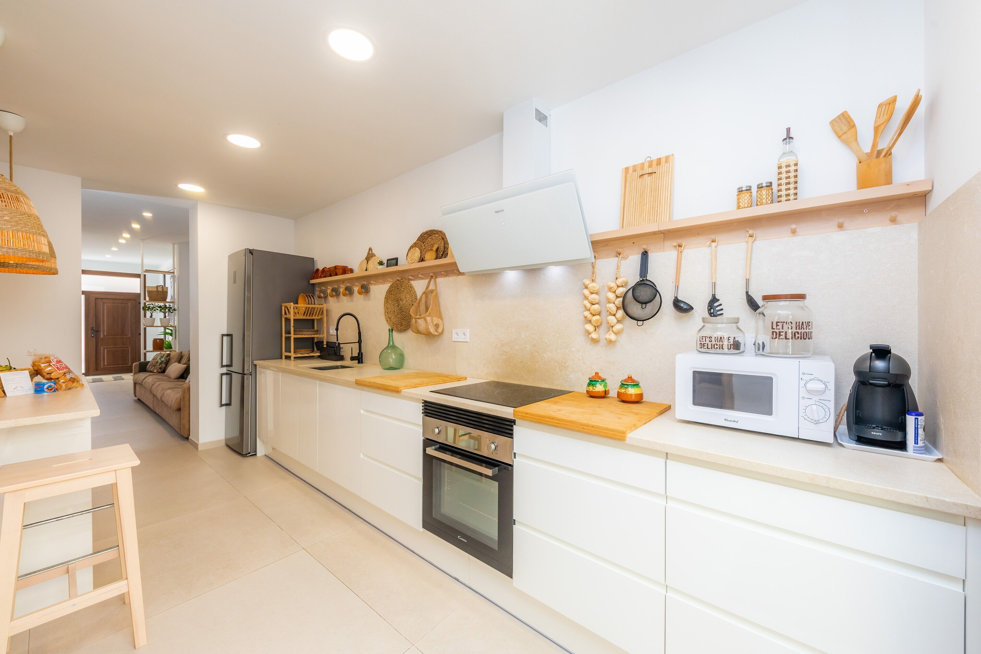 A modern kitchen with a built-in oven, microwave, and a coffee maker on the countertop.