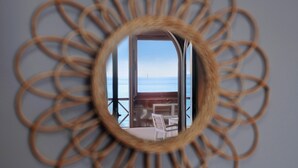 A circular mirror with a view of a balcony and a table. - Apartment "La Estrella" Near Beach with Panoramic Sea View, Terrace, A/C & Wi-Fi (Playa Blanca)