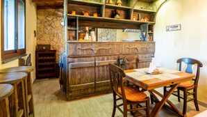 Un intérieur rustique avec des meubles en bois, un mur en pierre et une enseigne représentant une tasse de café.