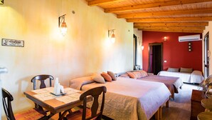Une chambre avec deux lits, une table à manger avec des chaises et un panneau indiquant qu’on y sert du café.