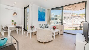 A modern living room with a sofa, chairs, a dining table, and a TV. - MIRADOR BLUE G   Ref: CS20 (Cala Sant Vicenç)