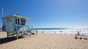 A lifeguard tower with a flag on top, located on a sandy beach with the ocean in the background. - 2/2 Beach Bungalow With Ocean Views & Parking! (Manhattan Beach)
