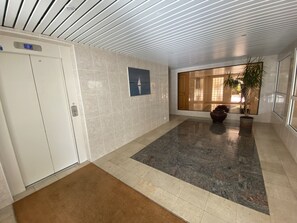 A spacious lobby with a tiled floor, a reception desk, a potted plant, and a large window. - T3 in Arcachon with sea view, private parking, and Wi-Fi (Arcachon)