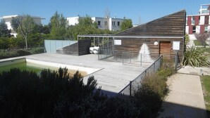 A modern building with a sloped roof, a covered outdoor area, and a swimming pool. - 2-Room Apt in Sète with Terrace and Garage (Sète)
