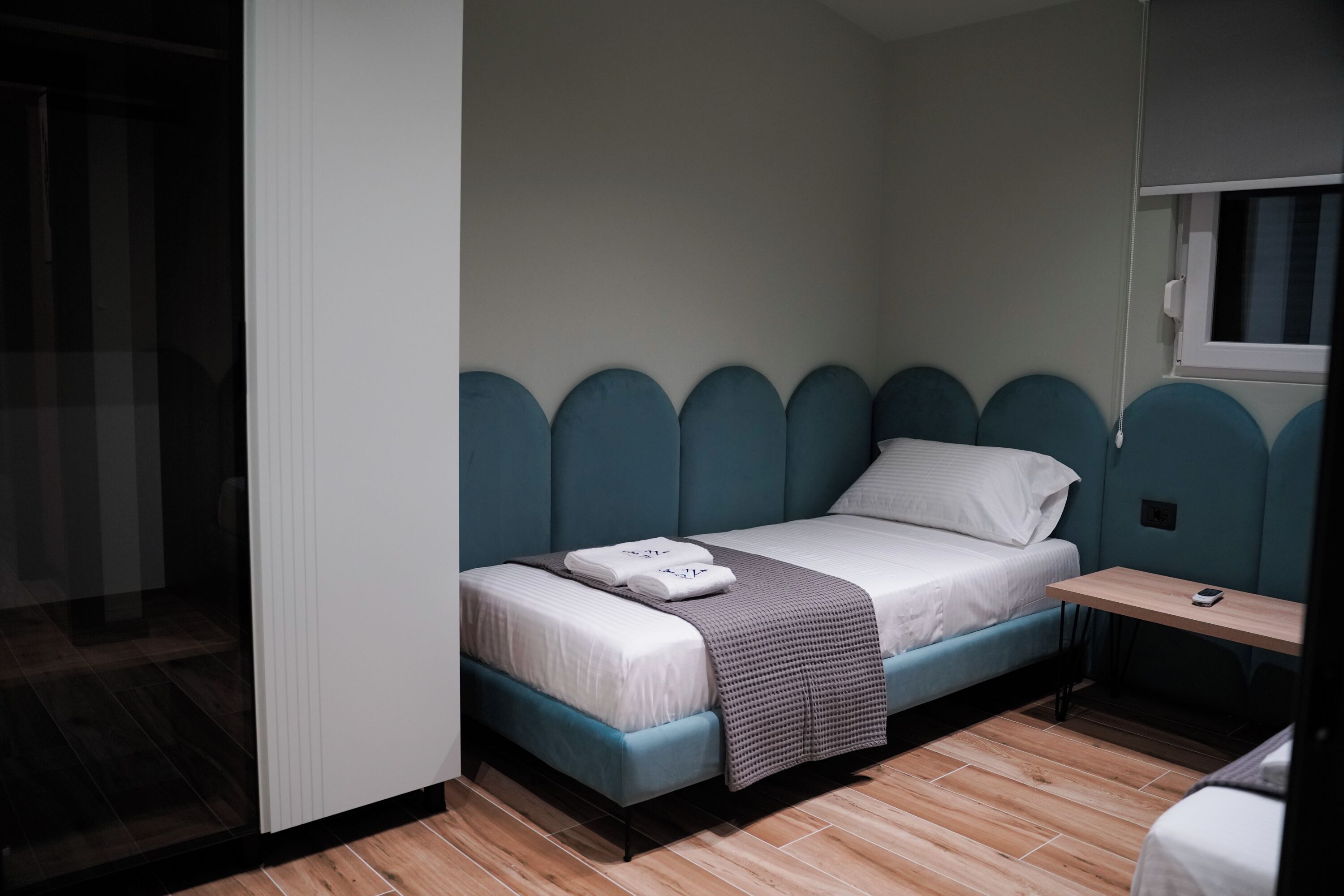 A compact room with a bed, a small table, and a window.
