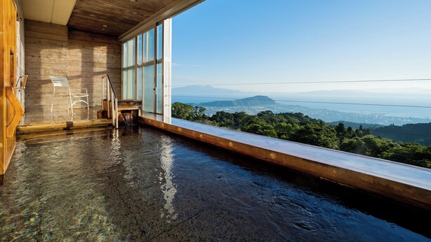 A modern interior with a large window offering a view of a mountainous landscape. - amafuru-oka (Ibusuki)