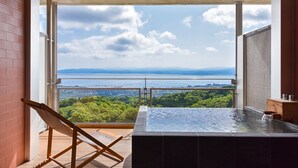 A balcony with a view of a body of water and greenery. - amafuru-oka (Ibusuki)