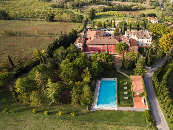 Situated on a hillside, this property offers expansive views of the surrounding landscape and an outdoor area with a swimming pool.