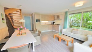 A modern apartment with a kitchen, dining area, and living room.