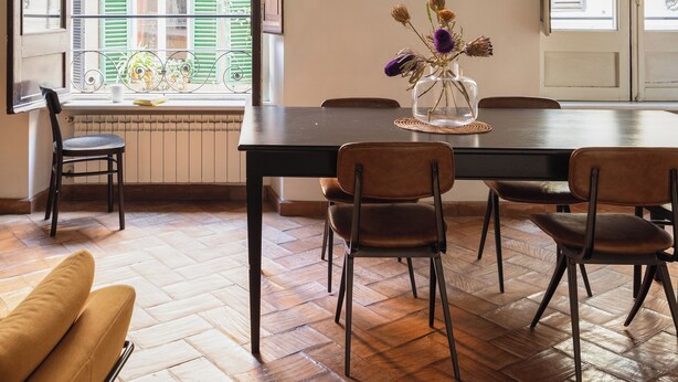 An open dining area with a wooden table, chairs, and a hanging light fixture. - Family Suite 4 bedrooms with Terrace (Roma)
