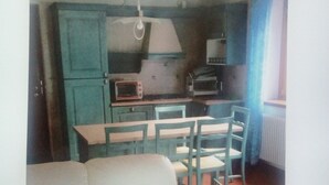 A compact living space with a sofa, dining table, chairs, and a kitchenette. - Downtown apartment, pets allowed (Paularo)